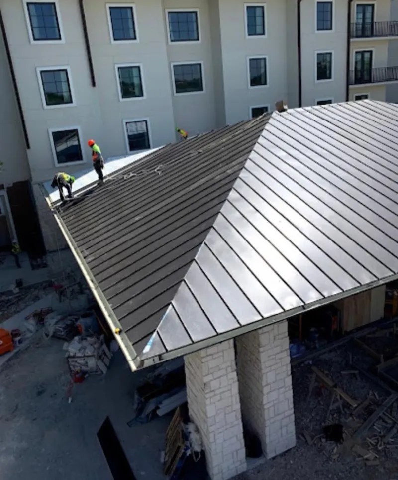 Crew installing standing seam metal roof panels on a commercial project in Wheat Ridge
